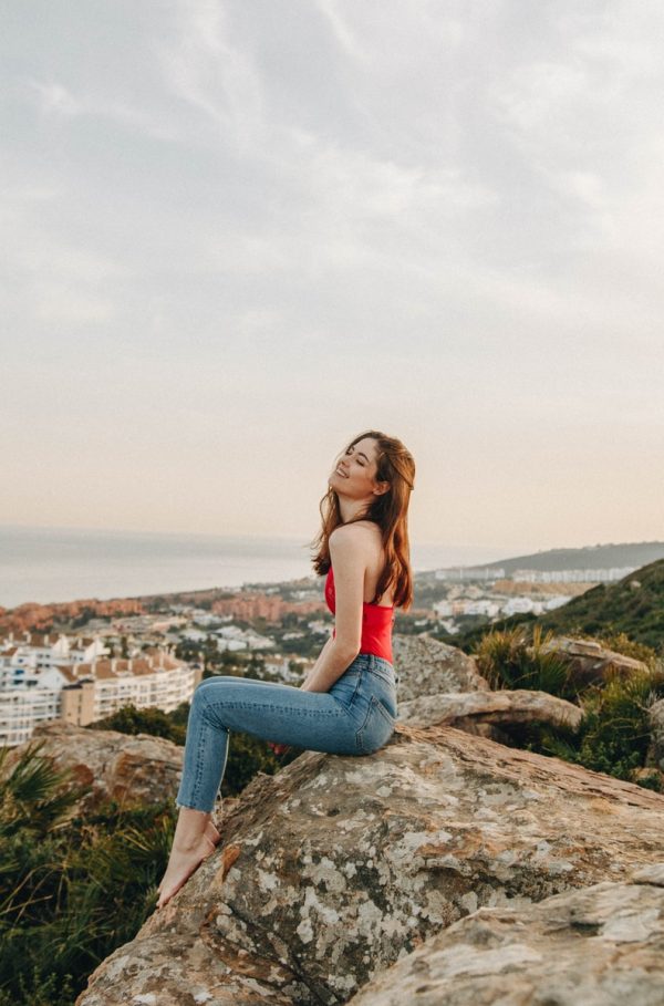 woman sitting on rock during daytime